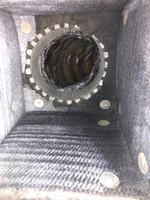 View inside a metallic ventilation duct, showing spiral-shaped inner walls and several round fasteners. The surface appears dusty, highlighting the importance of air duct services New Jersey for maintaining clean, efficient airflow.