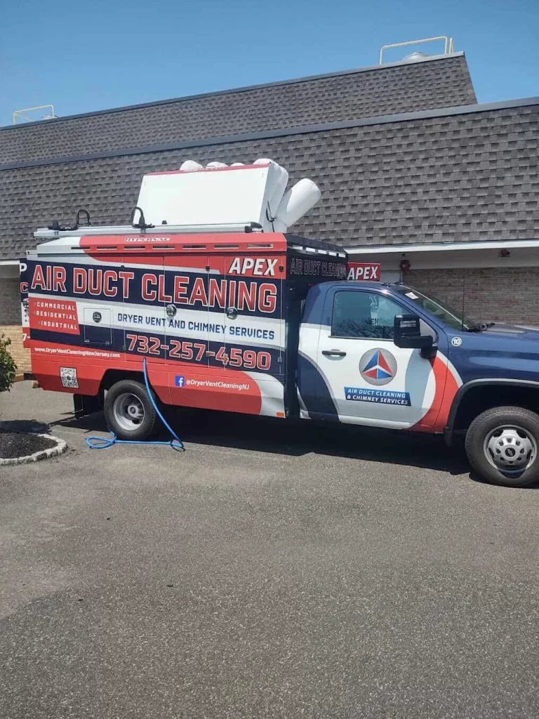 A van parked outside a building displays large text advertising "Apex Air Duct Cleaning," offering air duct services New Jersey, dryer vent and chimney services, with a phone number and company logo visible on the vehicle.
