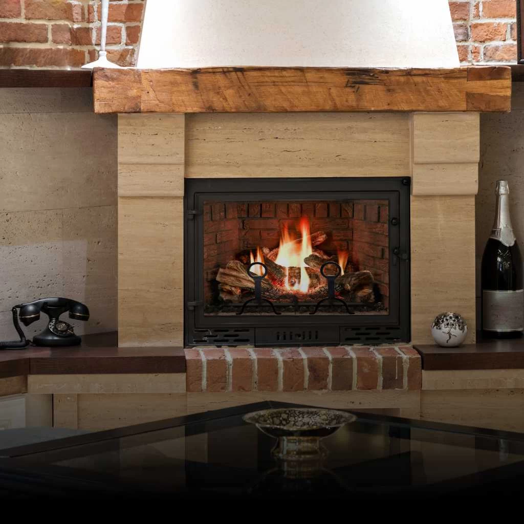A cozy fireplace with a burning fire, set in a brick and stone surround. On the mantel are a vintage telephone, a decorative vase, and a champagne bottle&mdash;ideal comfort after expert air duct services New Jersey. A glass-top table is visible in the foreground.